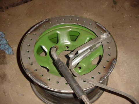 1992 Ford Bronco - A custom beadlock wheel is shown with a brake rotor and welding equipment, indicating a modification process.