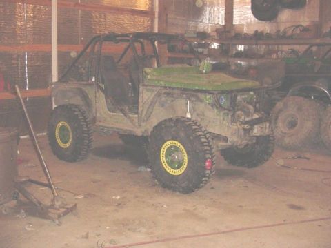 1992 Ford Bronco - Custom off-road vehicle with large tires and a roll cage in a garage setting.