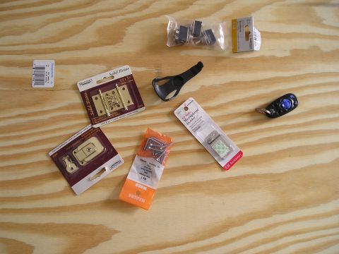 1996 Ford Bronco - Hardware and car accessories laid out on a wooden surface, including latches, screws, and a microphone holder.