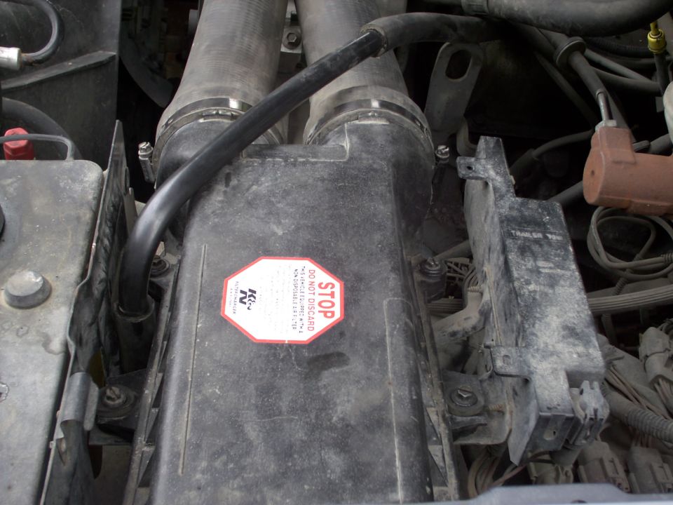 Engine bay air intake with K&N sticker and STOP DO NOT DISCARD warning