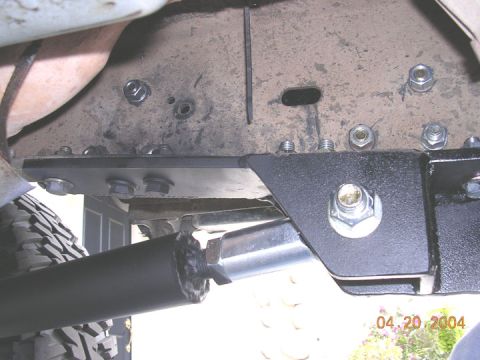 1994 Ford Bronco - Aftermarket suspension parts are bolted to the vehicle's frame, with a tire visible in the lower left corner.
