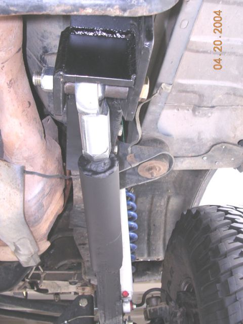 1994 Ford Bronco - Aftermarket suspension parts and exhaust system visible from underneath a vehicle.