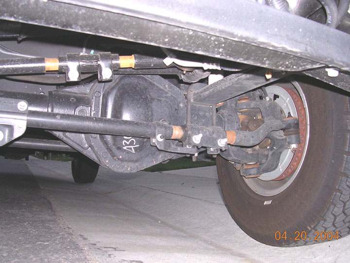 Solid front axle with crossover steering linkage and tie rod ends under a truck, 2004