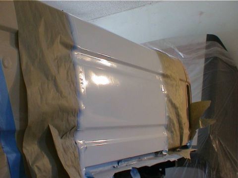 1979 Ford Bronco - A vehicle panel is being prepped and painted, covered in protective materials.