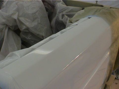 1979 Ford Bronco - A white painted car part is covered in plastic sheeting, with a website logo visible.