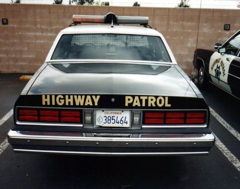 1995 Ford Crown Victoria - This older model highway patrol car has a light bar on top and California plates.