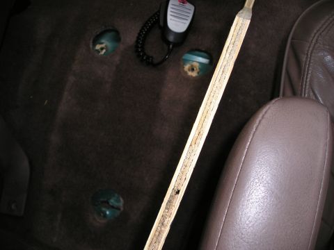 1996 Ford Bronco - Interior view of a vehicle showing floor mounts and a microphone, with a brown leather seat visible.
