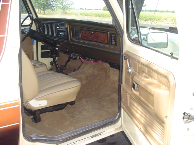 Interior of 1979 Ford Bronco showing tan seats, dashboard, and door panel