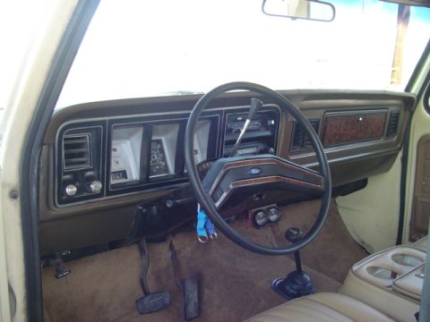 1979 Ford Bronco - The interior of a 1979 Ford Bronco shows its dashboard, steering wheel, and floor pedals.