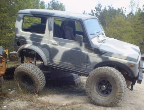 1989 Ford Bronco - Camouflaged Suzuki Samurai modified for off-road use with a lifted suspension.