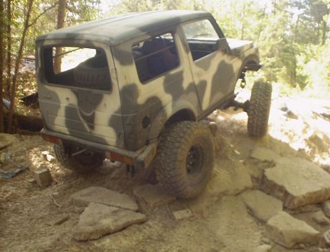 1989 Ford Bronco - Suzuki Samurai navigating a challenging rocky off-road course.
