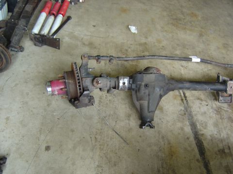1993 Ford Bronco - Front axle assembly with disc brakes and red hub, likely for a truck or SUV.