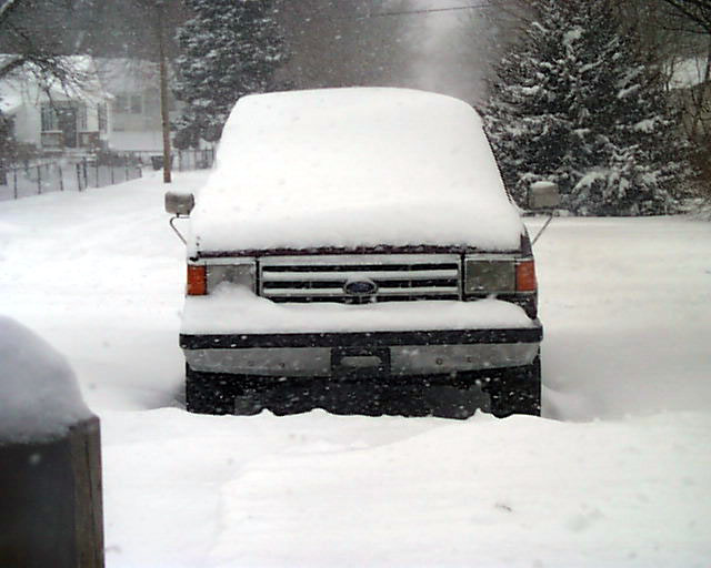 Ford truck front end buried in deep snow during a snowstorm