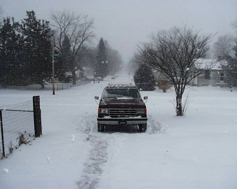 1988 Ford C-350 (Centurion Conversions) - A maroon van is parked in a snow-covered driveway on a cloudy day.
