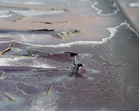 1988 Ford C-350 (Centurion Conversions) - Close-up view of extensive paint damage and rust on a vehicle's roof.