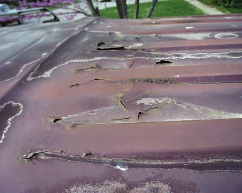 1988 Ford C-350 (Centurion Conversions) - The corrugated roof section shows extensive rust damage with multiple holes and cracks.