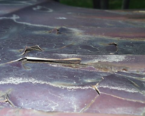 1988 Ford C-350 (Centurion Conversions) - Peeling paint and rust damage visible on the roof of a vehicle.