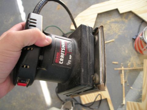 1996 Ford Bronco - A hand holds a Sears Craftsman orbital sander, showing its 1/6 HP motor and power switch.