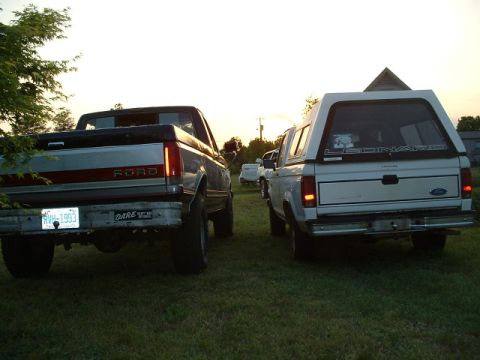1992 Ford Ranger - Two Ford trucks are parked side-by-side in a grassy area at dusk. The truck on the left has a license plate from 1993.