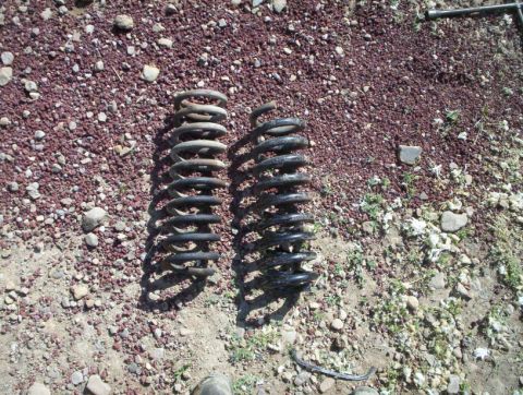 1978 Ford Bronco - Two coil springs are shown on the ground, possibly for a vehicle modification or repair.