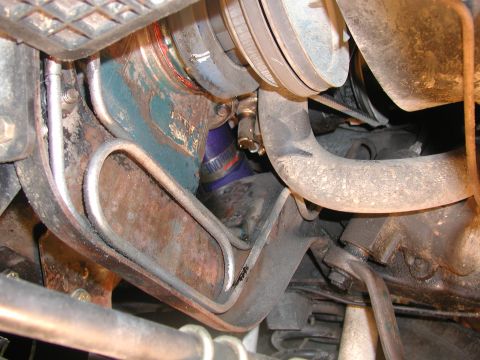 1985 Ford Bronco - Close-up view of engine components, including hoses, pulleys, and a blue filter.