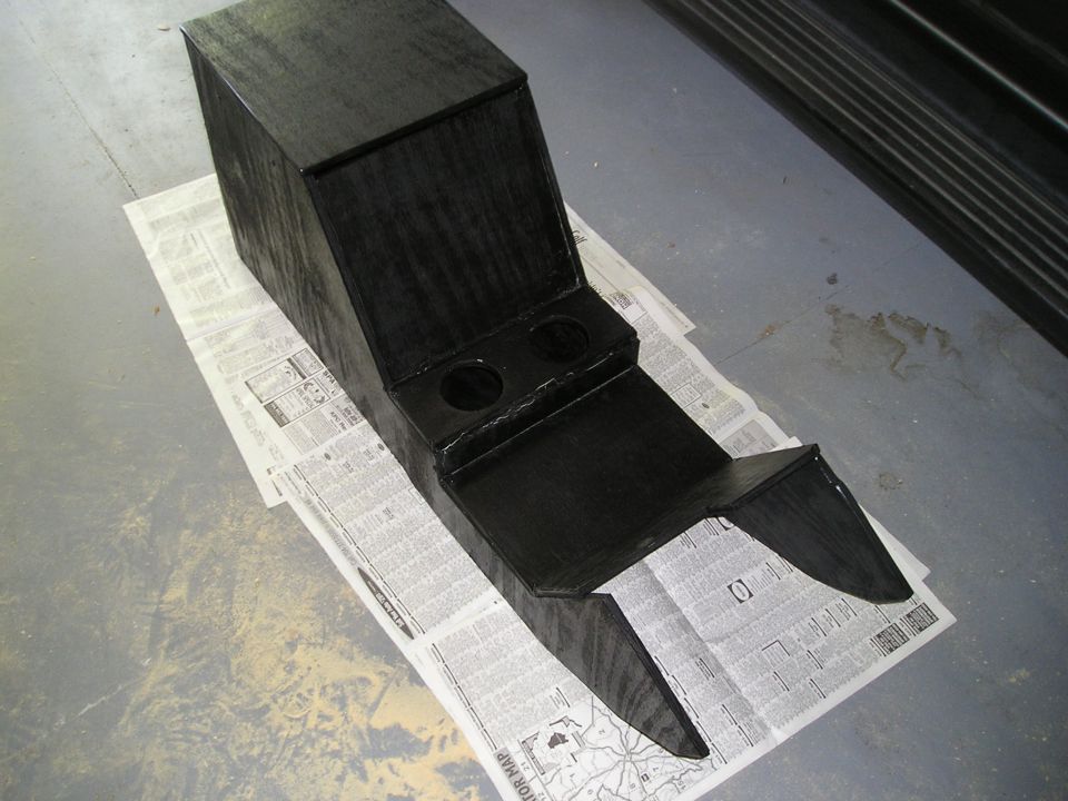 Glossy black custom center console with twin cup holders drying on newspaper.