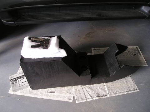 1996 Ford Bronco - Custom center console part with a stapler and padding, placed on newspapers.