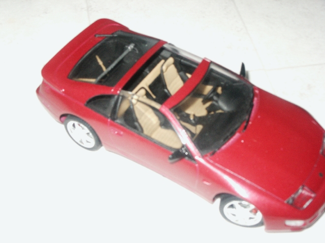 Red convertible model car with tan interior, viewed from above and front-right