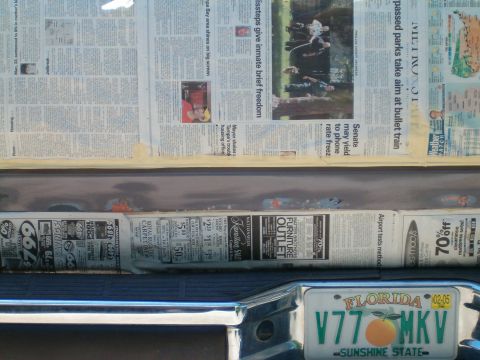 1991 Ford Bronco - Newspaper is used to protect the tailgate of a vehicle during a repair process.