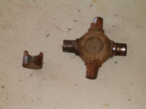1991 Ford Bronco - Rusty universal joint cross and a separate bearing cap shown on a concrete surface.