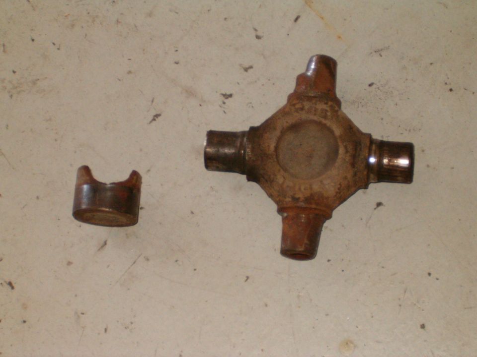 Universal joint cross and a bearing cap, both rusty