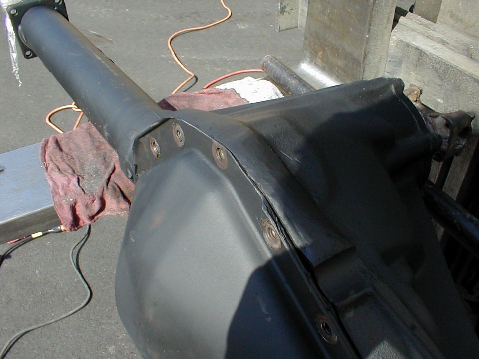 Freshly painted black axle housing center section and tube on a stand