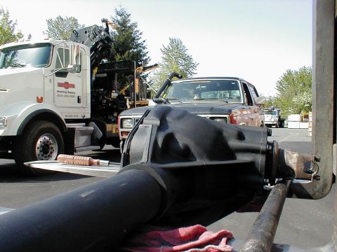 1983 Ford Bronco - A freshly painted black solid axle housing with high-pinion differential and inner axle shaft rests on a truck bed with a red shop rag, pho…