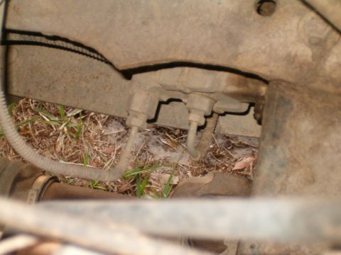 1991 Ford Bronco - Close-up view of brake lines and suspension components, likely from the underside of a vehicle.