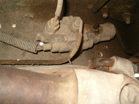1991 Ford Bronco - Close-up of a brake proportioning valve and associated components, likely from a vehicle's undercarriage.