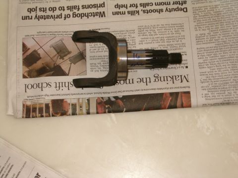 1991 Ford Bronco - A metal automotive part, likely a U-joint and shaft, rests on a newspaper.