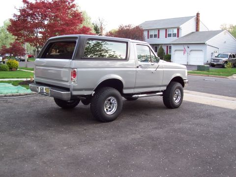 1990 Ford Bronco - This 1990 Ford Bronco is shown in a 3/4 front view, lifted with aftermarket wheels and a black removable top.