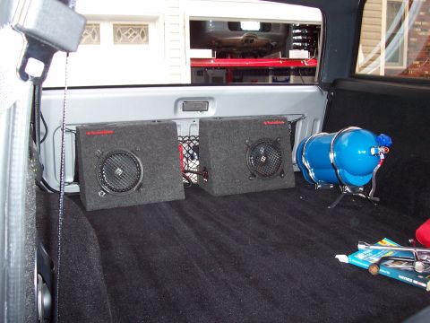 1990 Ford Bronco - Vehicle interior shows aftermarket audio equipment and a nitrous tank installed in the cargo area.