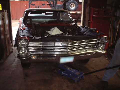 1967 Ford Galaxie - Front view of a 1967 Ford Galaxie undergoing engine work in a garage.