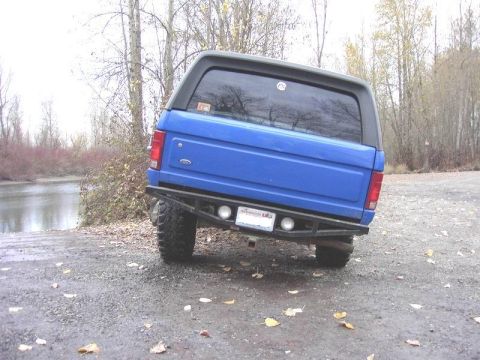 1980 Ford Bronco - Rear view of a blue 1980 Ford Bronco with a custom bumper and aftermarket lights.