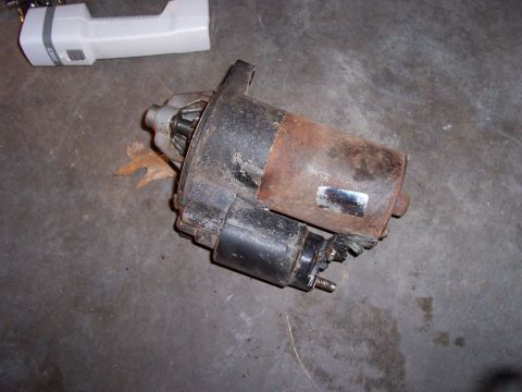 1994 Ford Bronco - A worn starter motor sits on a concrete surface, with a flashlight in the background.