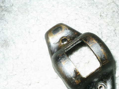 1984 Ford Bronco - A close-up view of a metal engine part, likely a rocker arm, showing signs of wear and use.