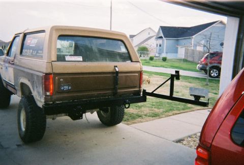 1983 Ford Bronco - This 1980 Ford Bronco features a rear-mounted spare tire carrier, with another vehicle partially visible in the foreground.