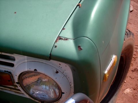 1972 Ford Bronco - Close-up of a 1972 Ford Bronco's front fender shows signs of rust and wear.