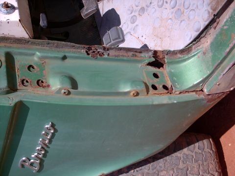1972 Ford Bronco - Rust damage is visible on the door frame of this 1972 Ford Bronco, with interior pedals also in view.