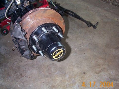 1986 Ford Bronco - A Dana 60 front axle assembly part is shown, with a Warn Premium hub and brake components visible.