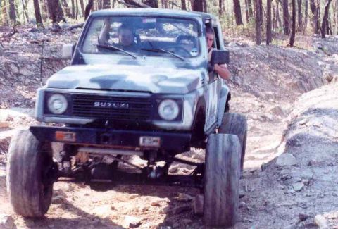 1989 Ford Bronco - A Suzuki Samurai navigates a challenging off-road course with large, aggressive tires.