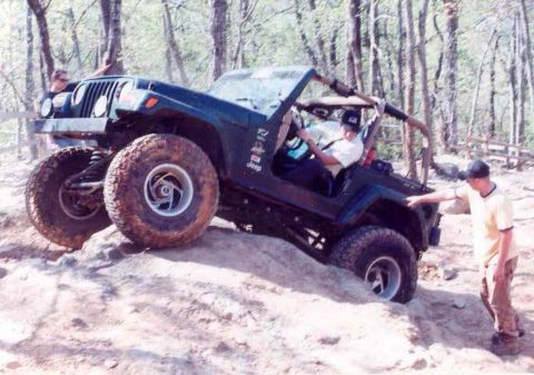 1989 Ford Bronco - Jeep Wrangler TJ navigating a rocky off-road trail with assistance from a spotter.