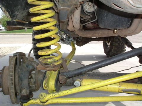 1979 Ford Bronco - Modified suspension components with yellow paint and a chain are visible in this close-up view.