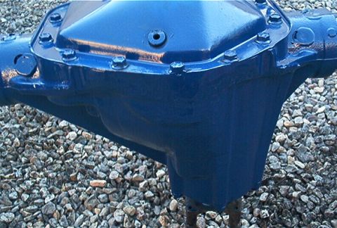 1986 Ford Bronco - A blue painted rear axle differential housing sits on a bed of gravel.